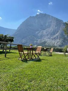 a table and chairs with a mountain in the background at Serendipity House Valle dei Laghi in Sarche di Calavino