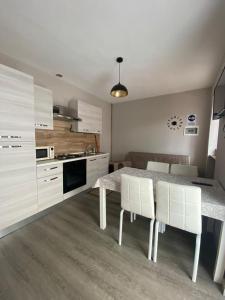 eine Küche mit einem Tisch und einigen weißen Schränken in der Unterkunft Casa Vacanze Spolina in Cossato