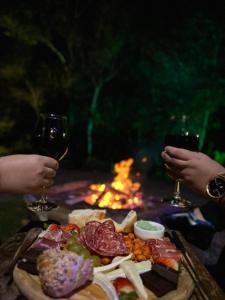 una mesa con un plato de comida y dos copas de vino en Reserva Brasileira, en Praia do Rosa