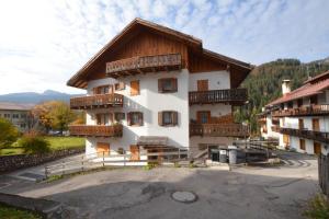 a building with wooden balconies on the side of it at Cà Enrosadira primo piano in San Vito di Cadore