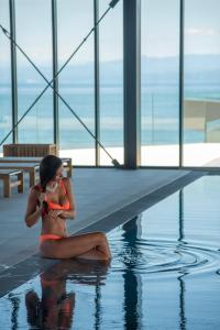 a woman in a bikini sitting in a swimming pool at Petram Resort & Residences in Savudrija