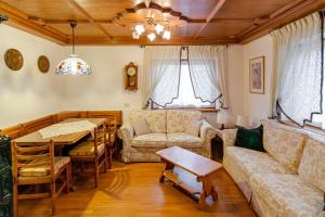 a living room with a couch and a table at Cà Enrosadira primo piano in San Vito di Cadore