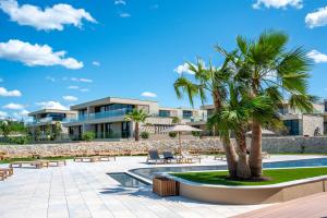 a resort with a palm tree and a pool at Petram Resort & Residences in Savudrija