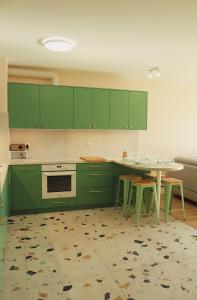 una cocina con armarios verdes y una mesa con sillas en Malta Lake - Apartment, en Poznan