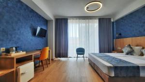 um quarto de hotel com uma cama e uma secretária e um quarto em Hotel DownTown Avlabari em Tbilisi