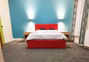 a bedroom with a red bed and blue walls at Modern En-suite Doubles near Boston Town: Spacious & Contemporary Rooms in Lincolnshire