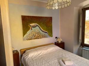 1 dormitorio con 1 cama y una pintura en la pared en Casa in centro storico a Carrara, en Carrara