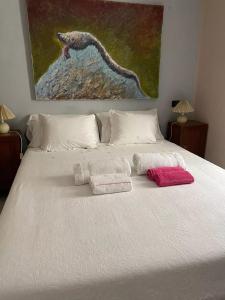 1 dormitorio con 1 cama blanca y 2 toallas en Casa in centro storico a Carrara, en Carrara