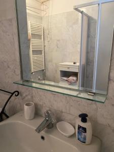 a bathroom with a sink with a mirror above it at Casa in centro storico a Carrara in Carrara