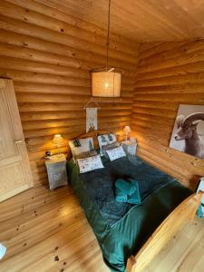 Habitación con cama en una cabaña de madera en Magnifique chalet avec SAUNA, en Roubion