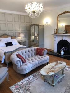a bedroom with a couch and a bed and a chandelier at The Old Dispensary in Kinsale