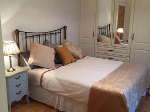 a bedroom with a bed and a dresser with a mirror at The Old Dispensary in Kinsale