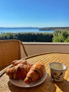 einen Teller Croissants und eine Tasse Kaffee auf dem Tisch in der Unterkunft L'Ancora Blu in Porto Torres