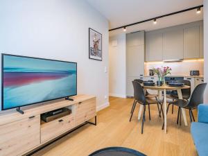 een woonkamer met een grote flatscreen-tv bij Hello Apartments RIO with private parking in Gdańsk