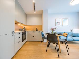 a kitchen and living room with a table and chairs at Hello Apartments RIO with private parking in Gdańsk