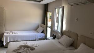 Likya Inn - Dodurga&Patara Evleri في Gâvurağılı: غرفة بسريرين ونافذة