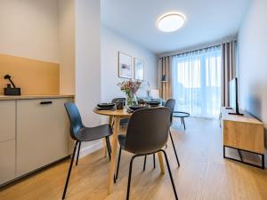 a kitchen and a dining room with a table and chairs at Hello Apartments RIO with private parking in Gdańsk +26 photos