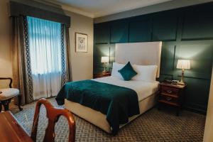 une chambre d'hôtel avec un lit doté d'une tête de lit verte dans l'établissement Abbey Hotel Roscommon, à Roscommon
