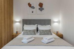 a bedroom with a bed with three towels on it at Athinais Luxury Studio 2 in Athens