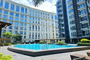 a swimming pool in front of a large building at Tess and Tessha Condotel in Manila