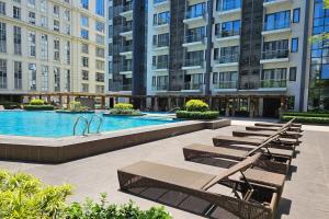 a pool in a building with a row of benches at Tess and Tessha Condotel in Manila