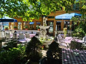 a fountain in front of a restaurant with tables and chairs at Höckner Plaza Hotel in Attnang-Puchheim