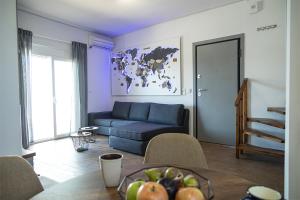 ein Wohnzimmer mit einem blauen Sofa und einem Tisch in der Unterkunft Sea Front Sophia Porto Rafti in Porto Rafti