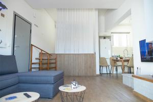 a living room with a blue couch and a table at Sea Front Sophia Porto Rafti in Porto Rafti