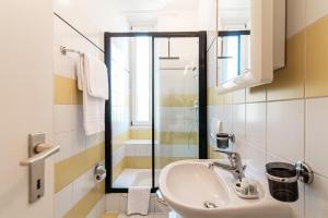 y baño con lavabo y ducha. en Giuka Apartment by Quokka 360 - close to the station, en Massagno
