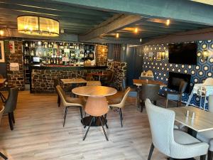 un restaurante con mesas y sillas y un bar en OYO Lamphey Hall Hotel, en Pembroke