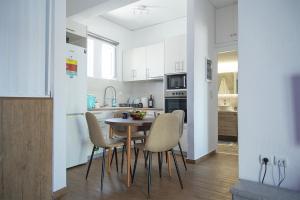 a kitchen with a table and chairs in a room at Sea Front Sophia Porto Rafti in Porto Rafti