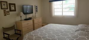Dormitorio con cama y tocador con TV en Holiday Villas II ON THE BEACH w/Intercoastal View, en Clearwater Beach