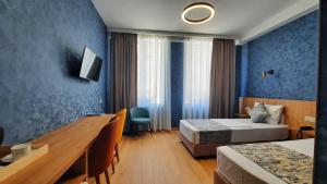 Habitación de hotel con 2 camas y escritorio en Hotel DownTown Avlabari en Tiflis