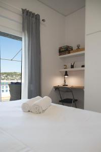 1 dormitorio con 1 cama con 2 toallas en Sea Front Sophia Porto Rafti, en Porto Rafti