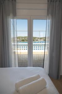 a bedroom with a bed with a view of the ocean at Sea Front Sophia Porto Rafti in Porto Rafti