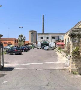 a parking lot with cars parked in front of a factory at La Maison de Marianne in Trepuzzi