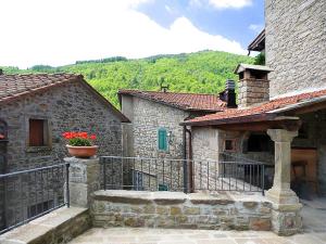 an old stone building with a flower pot on a balcony at B&B Il Fortino in Talla