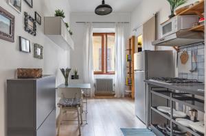 a kitchen with a refrigerator and a table with chairs at Giardino della Fortezza & San Lorenzo Central Flat in Florence