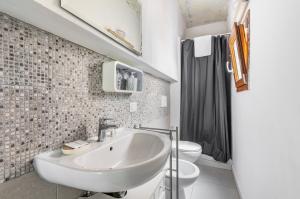a white bathroom with a sink and a toilet at Giardino della Fortezza & San Lorenzo Central Flat in Florence
