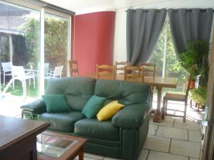 a living room with a green couch and a table at Maison détente CARRY-LE-ROUET in Carry-le-Rouet