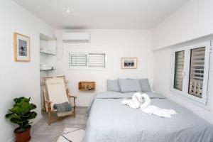 Prime Location 2BR Beach Flat في تل أبيب: غرفة نوم عليها سرير وفوط بيضاء