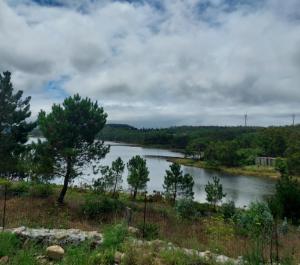 a view of a river with trees in the distance at Casa Rojo in Camariñas