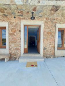 a door in a stone building with a sign that says i love at Casa Rojo in Camariñas