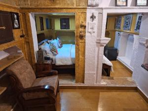 a bedroom with a bed and a couch and a chair at Desert Haveli Guest House in Jaisalmer
