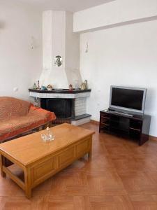 a living room with a fireplace and a television at Anastasias apartments in Sarandë
