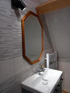 een badkamer met een witte wastafel en een spiegel bij Maison de la Ruelle, vue sur les toits de Domme in Domme
