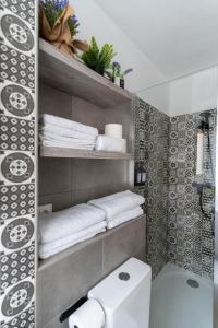 baño con aseo y toallas en un estante en Casa Moreda, en Almería