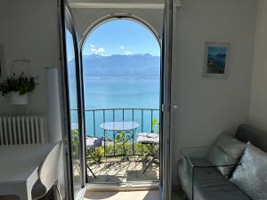 a room with a balcony with a view of the ocean at Room with 360° view overlooking Lake Geneva and Alps in Puidoux