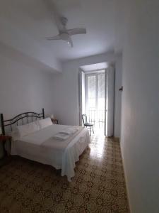 Schlafzimmer mit einem Bett und einem Deckenventilator in der Unterkunft Pensión Las Cuatro Naciones in Cádiz
