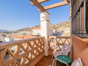 einen Balkon mit Stühlen und Stadtblick in der Unterkunft Cubo's Casa Ronda del Olivar in Pizarra